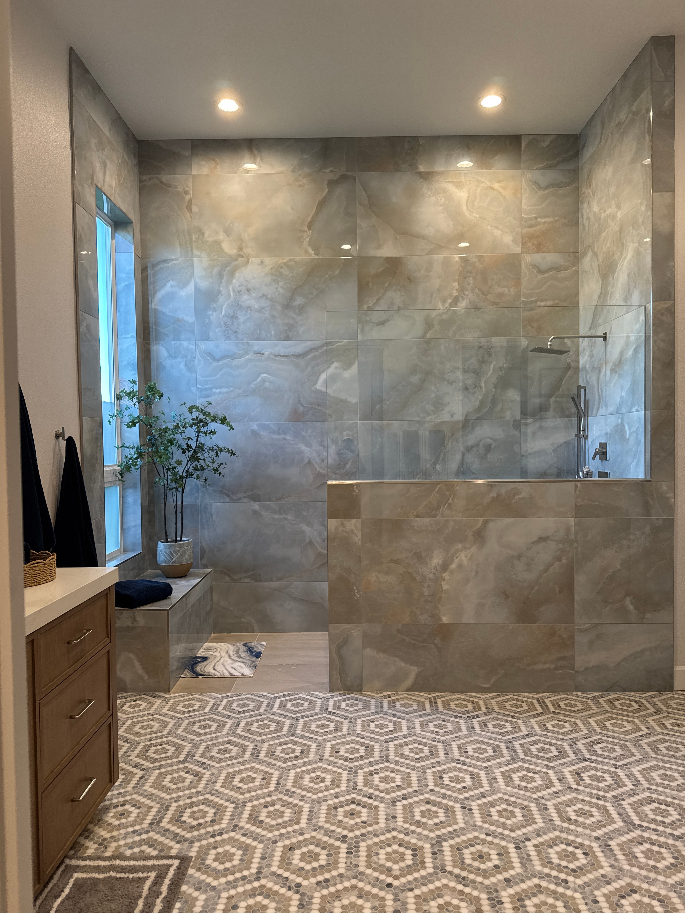 Mercer Lane primary bathroom after renovation — marble tile and mosaic accent wall