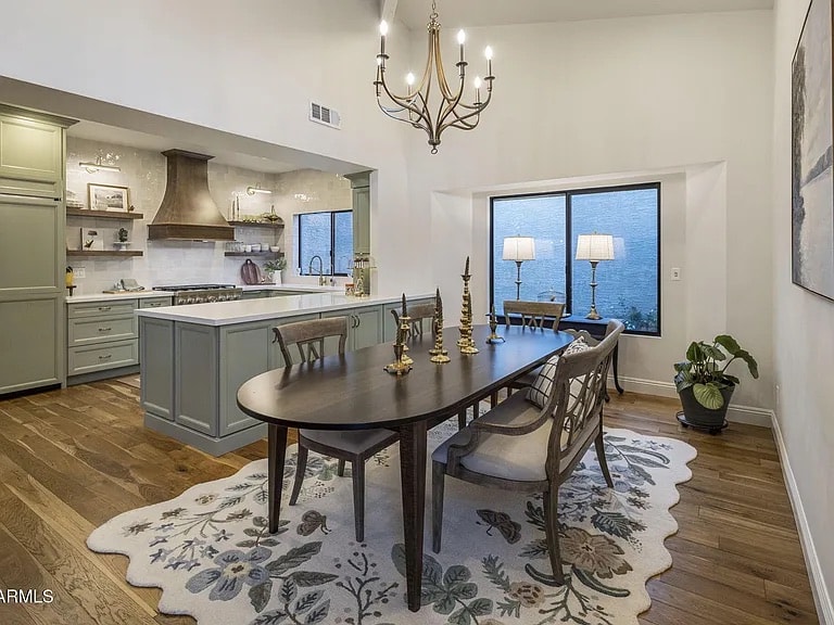 Mercer Lane dining and kitchen after renovation — sage green cabinetry and chandelier