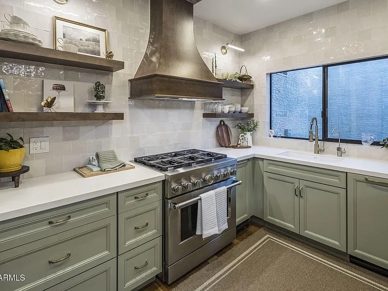 Mercer Lane kitchen after renovation — sage green cabinetry with brass hardware